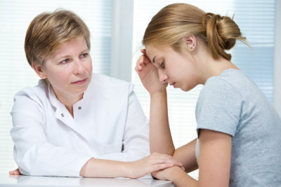 counselor talking to a teenage girl suffering with depression